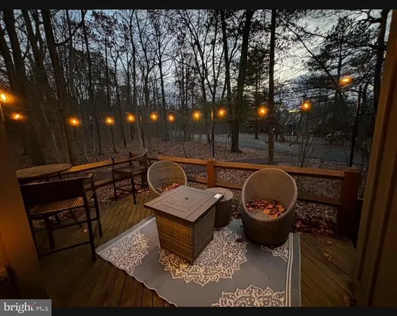 a view of a patio with table and chairs with wooden floor and fence