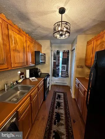 a kitchen with stainless steel appliances a stove a sink and a refrigerator