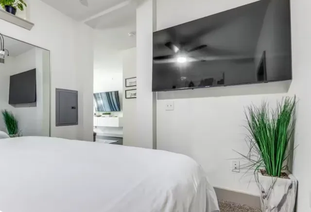 a bedroom with a bed and a flat screen tv
