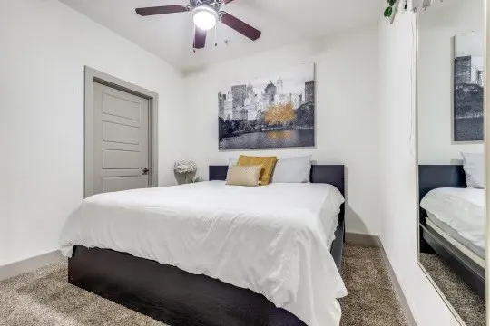 a bedroom with bed and paintings on wall