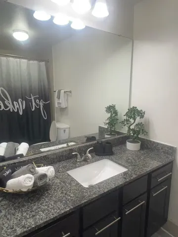 a bathroom with a granite countertop sink and a mirror