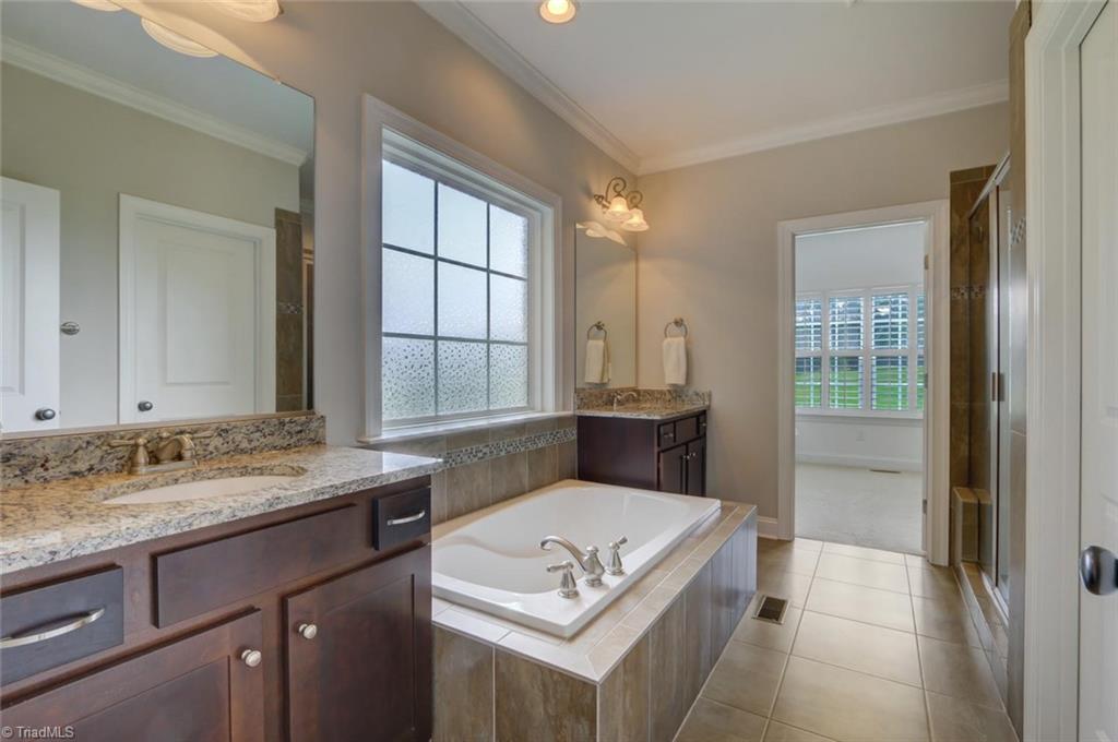 7772 Sutter Road Greensboro, NC 27455 - Photo 15 of 30 Double vanities with great soaking tub. Granite counter tops and view to HUGE walk-in closet!