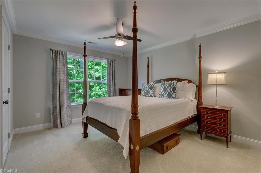7772 Sutter Road Greensboro, NC 27455 - Photo 18 of 30 This bedroom on the second level has a VERY large walk-in closet. Ceiling fan and crown molding again show some of the many details found in this home.