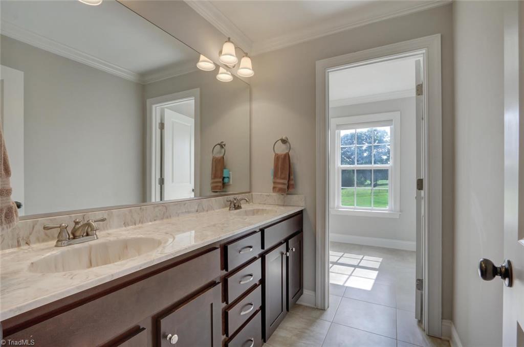 7772 Sutter Road Greensboro, NC 27455 - Photo 21 of 30 Oversize hall bath with double sinks, neutral tile and separate shower/bath combo!