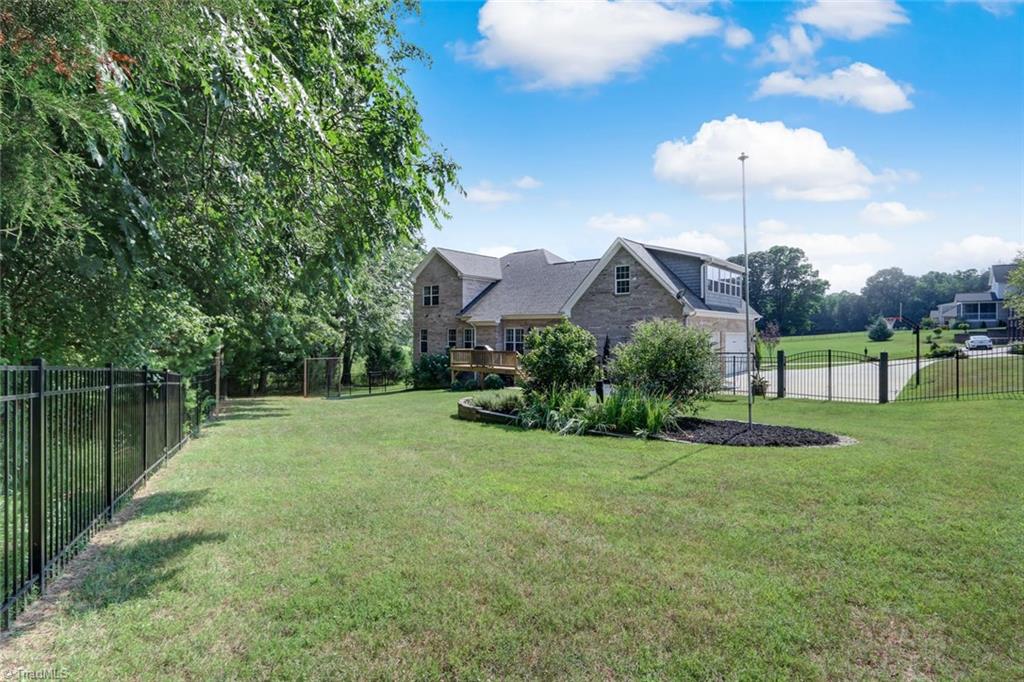 7772 Sutter Road Greensboro, NC 27455 - Photo 26 of 30 View from the back of the fenced portion of the yard! Flat driveway is great for basketball or toys!