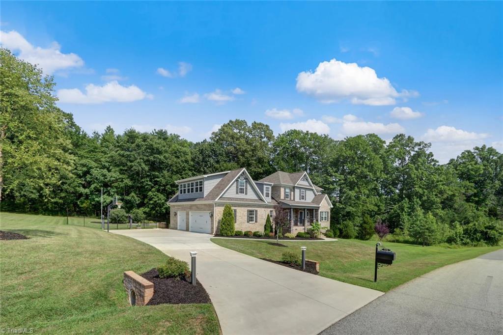 7772 Sutter Road Greensboro, NC 27455 - Photo 27 of 30 3 car side entry garage! Plenty of pave parking space! Trees surround this beautiful home that backs up to Northern Middle and Northern High School!