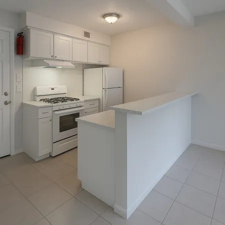 a kitchen with cabinets and white stainless steel appliances