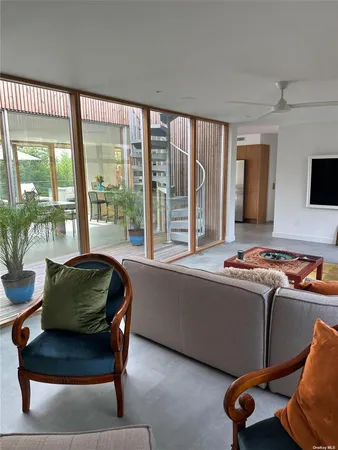 a living room with furniture and a floor to ceiling window