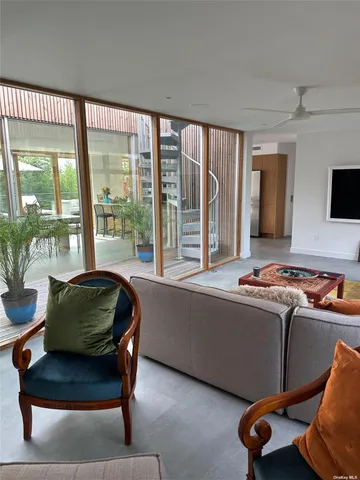 a living room with furniture and a floor to ceiling window