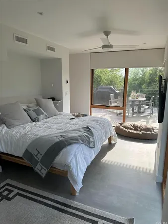 a bedroom with a bed and a large window