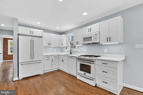 a bathroom with a toilet a sink a mirror and vanity