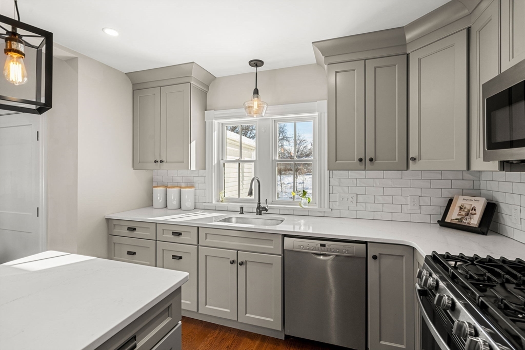 201 Main Street Rowley, MA 01969 - Photo 11 of 42 a kitchen with a sink stove and microwave