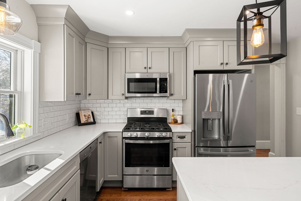 201 Main Street Rowley, MA 01969 - Photo 12 of 42 a kitchen with a stove a microwave and a sink