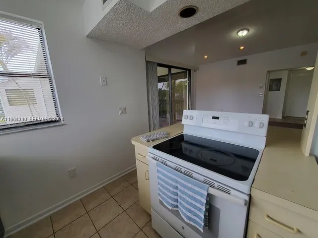 a kitchen with a stove and white cabinets