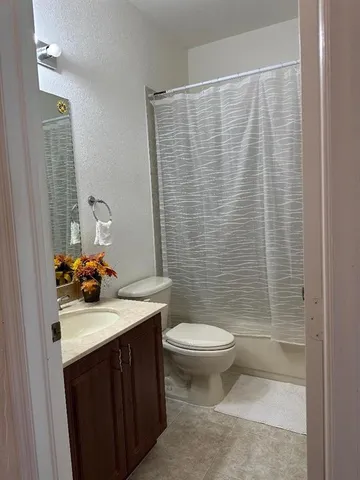 a bathroom with a sink a toilet and shower curtain