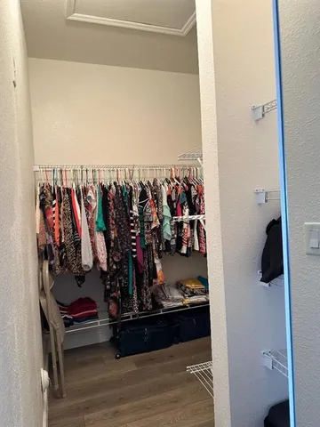 a view of walk in closet with clothes and shoes