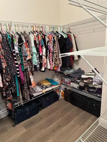 a view of walk in closet with clothes and shoes