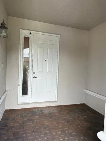 a view of an empty room with wooden floor and a cabinet