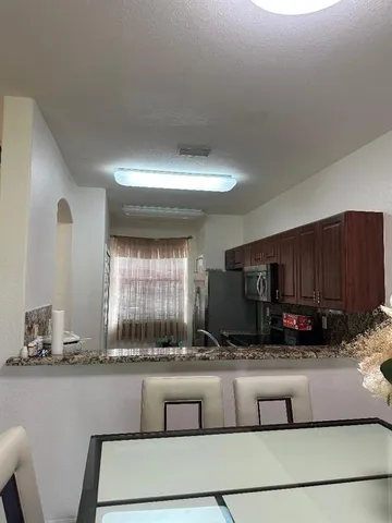 a kitchen with granite countertop a stove a sink and a wooden cabinets