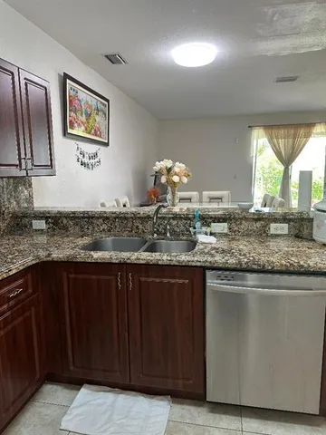 a kitchen with granite countertop a sink and cabinets