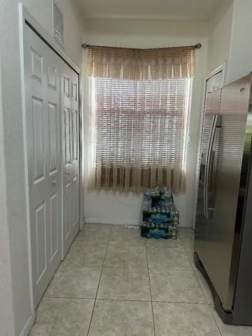 a kitchen with a refrigerator and glass windows