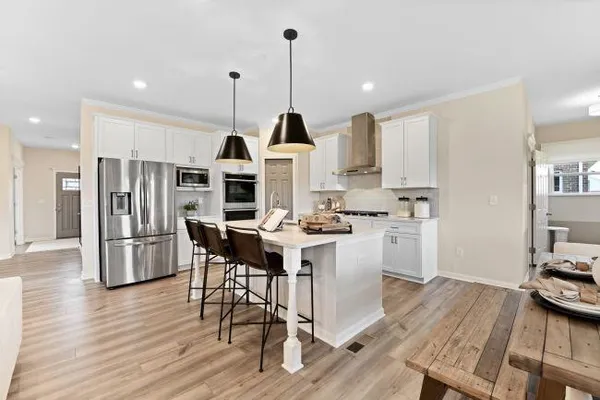a kitchen with a stove oven and a wooden floor
