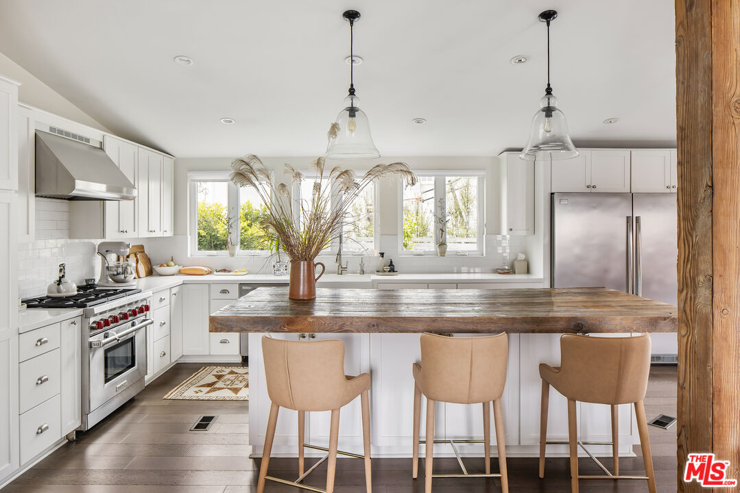 a kitchen with stainless steel appliances granite countertop a stove a sink and a refrigerator