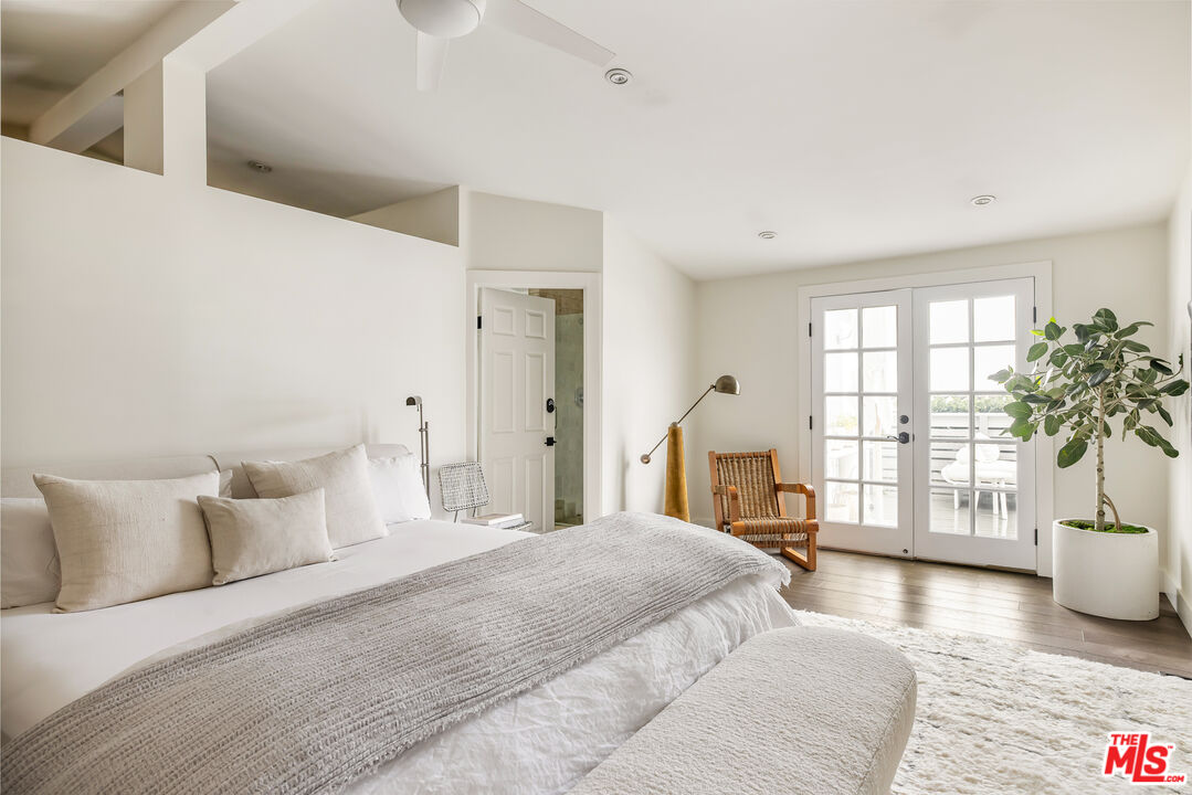 29500 Heathercliff Road, Unit 235 Malibu, CA 90265 - Photo 13 of 32 a spacious bedroom with a bed and a potted plant
