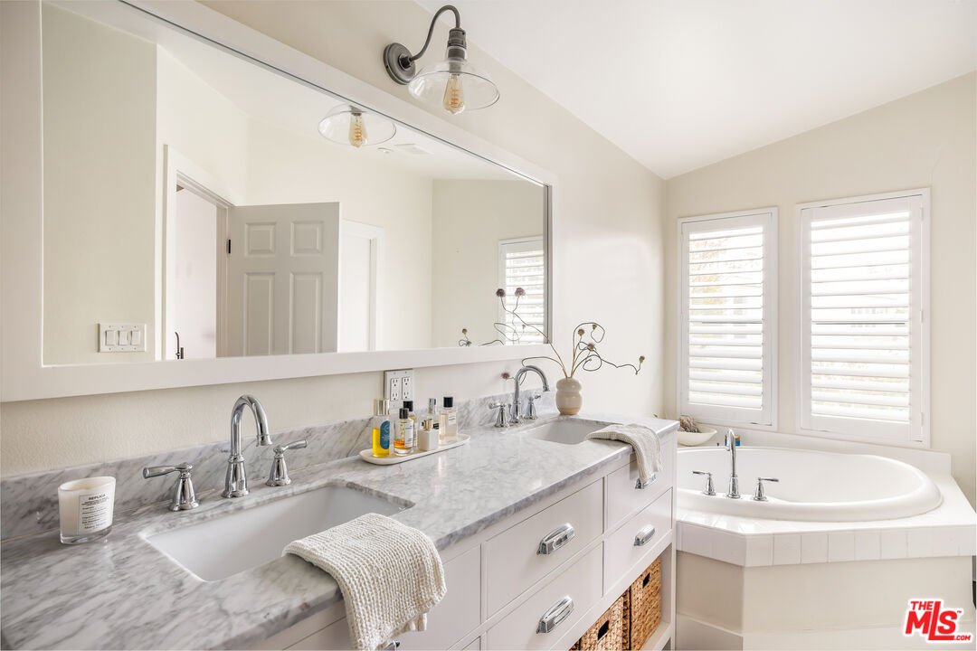 29500 Heathercliff Road, Unit 235 Malibu, CA 90265 - Photo 17 of 32 a bathroom with a granite countertop sink and a bathtub