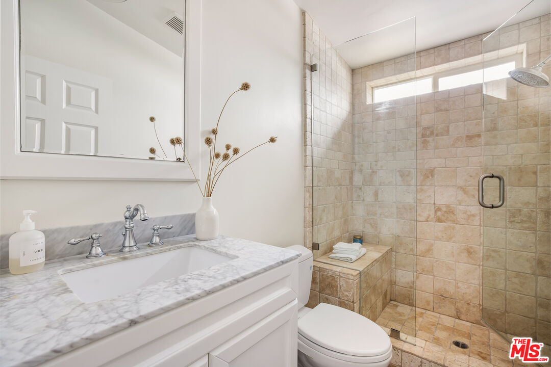 29500 Heathercliff Road, Unit 235 Malibu, CA 90265 - Photo 23 of 32 a bathroom with a granite countertop sink a toilet and a mirror