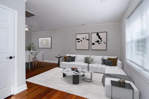 a view of an empty room with wooden floor and a window