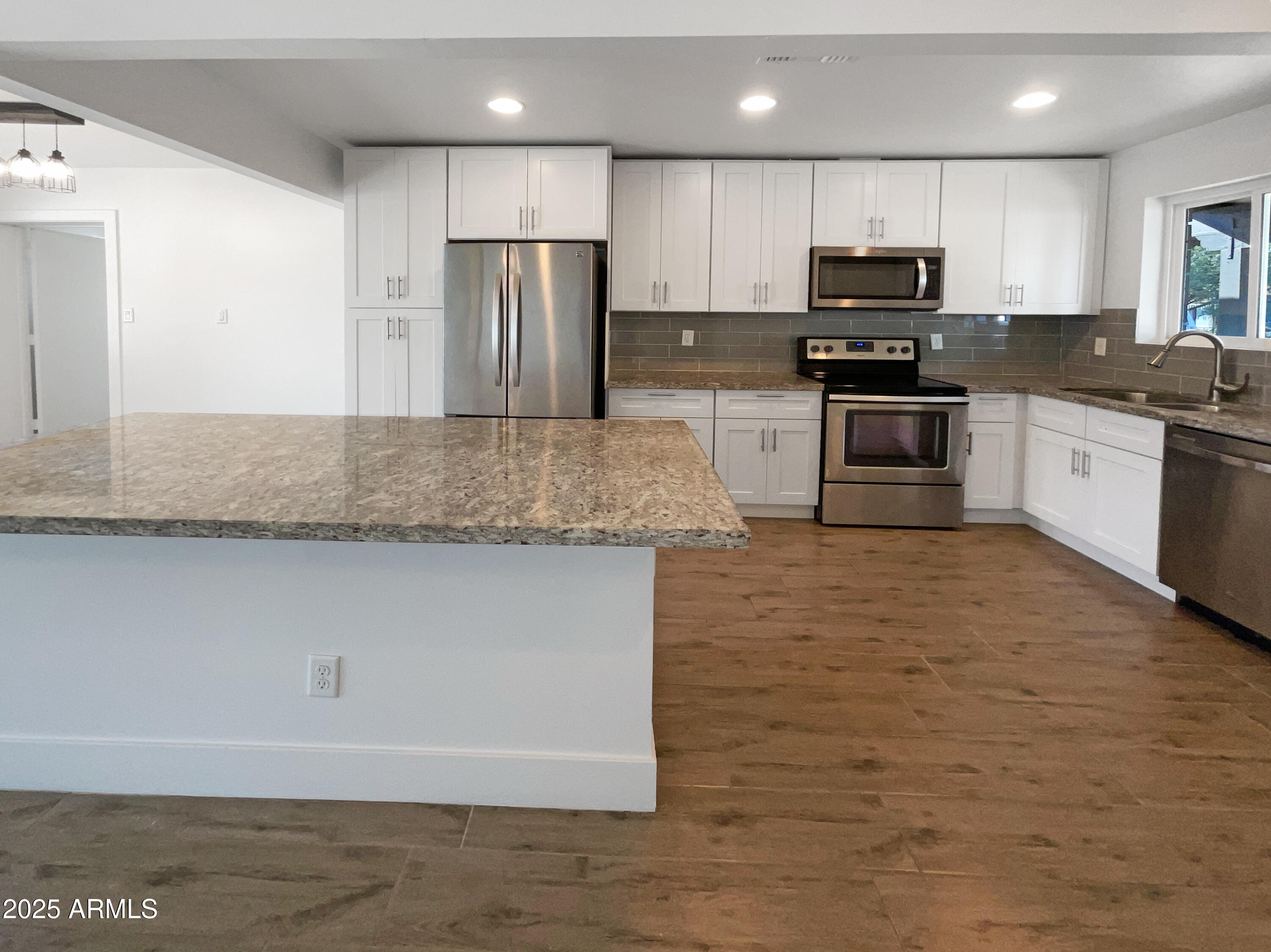 7231 North 23rd Avenue Phoenix, AZ 85021 - Photo 2 of 28 a view of kitchen with stainless steel appliances granite countertop a stove a sink a refrigerator and a microwave