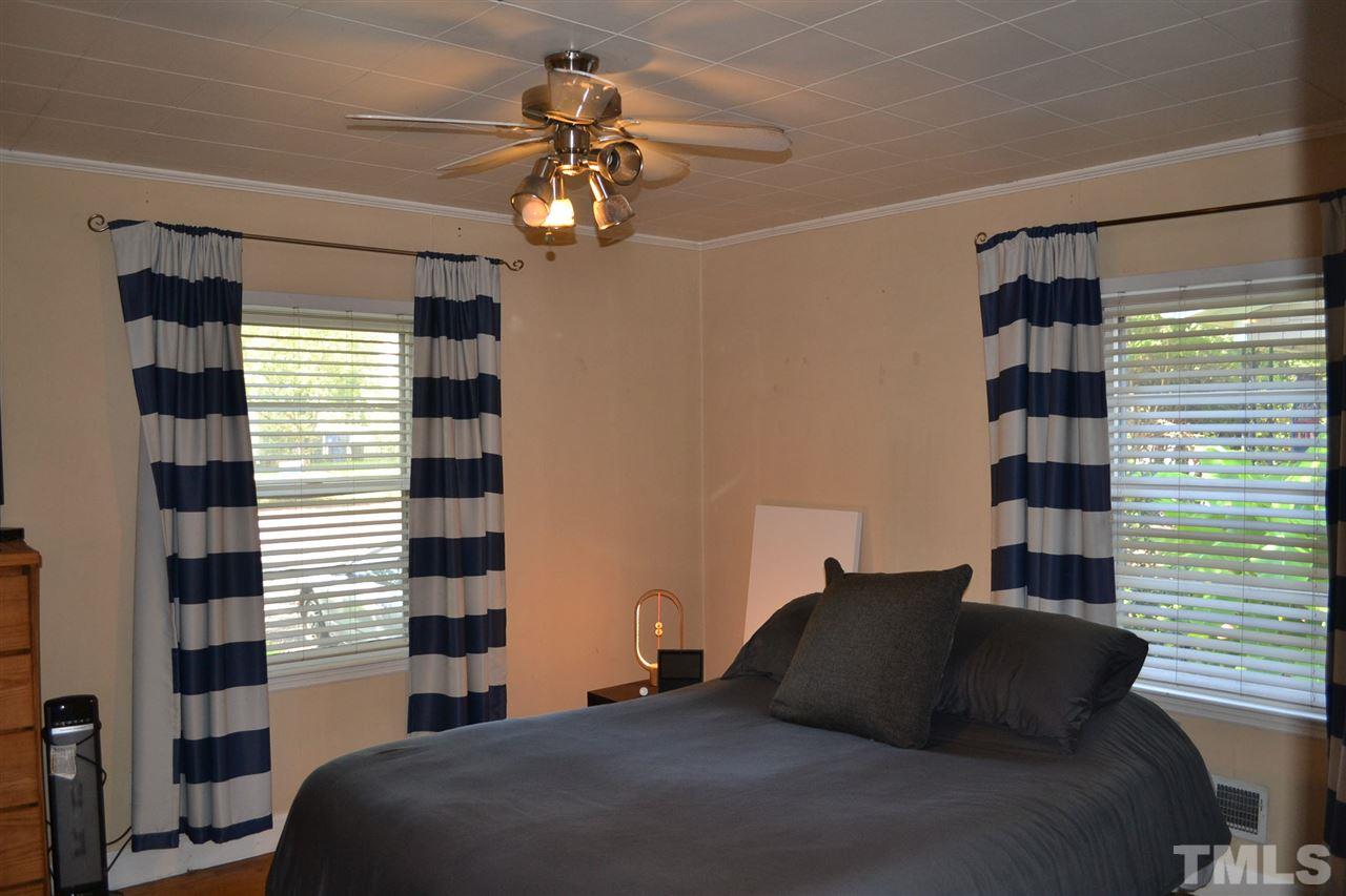 1604 Carson Street Raleigh, NC 27608 - Photo 14 of 28 a bedroom with a bed and a chandelier
