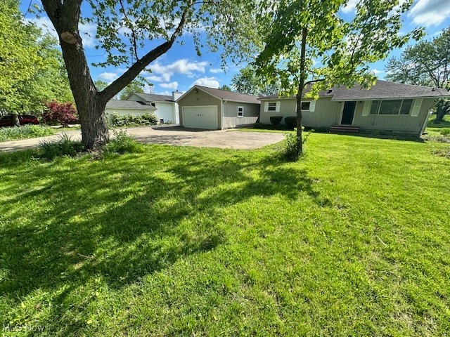7687 Chaffee Road Northfield, OH 44067 - Photo 3 of 23 View of front facade featuring asphalt driveway, a garage, and a front yard