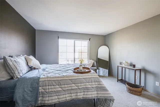 a bedroom with a bed a dresser and chair