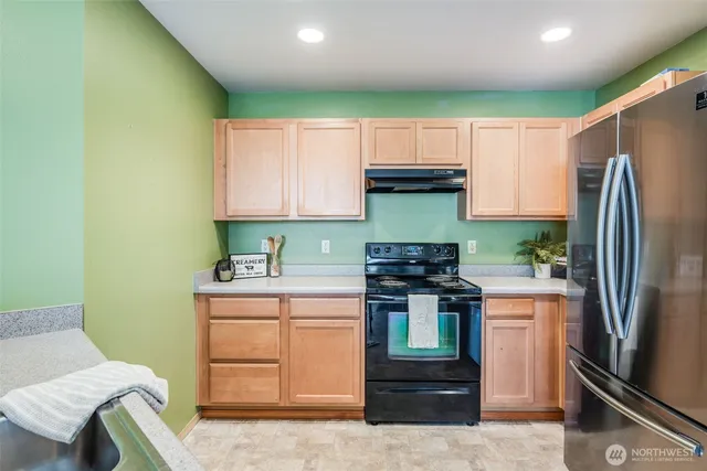a kitchen that has a sink a refrigerator and a stove