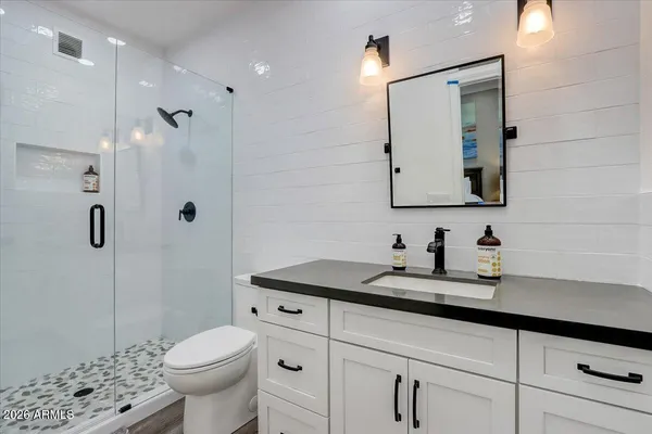 a bathroom with a granite countertop sink mirror vanity and toilet