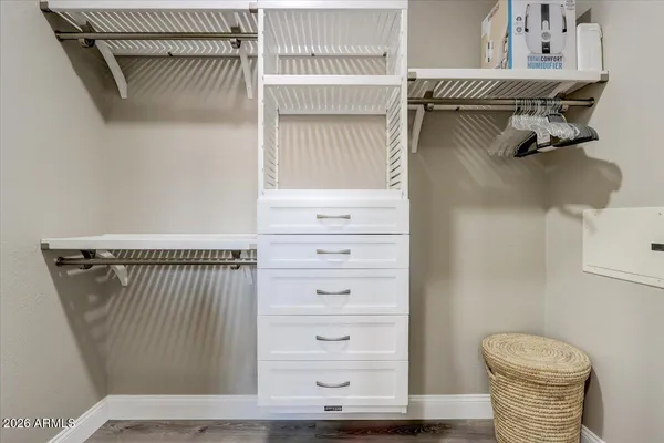 a view of walk in closet with clothes and shoes
