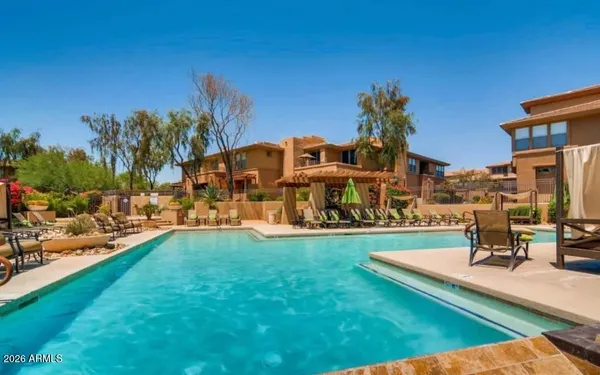 a view of a swimming pool with a bench and lawn chairs