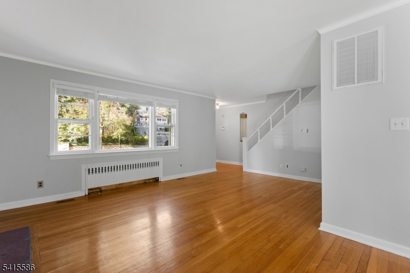 97 McCosh Road Montclair, NJ 07043 - Photo 3 of 25 an empty room with wooden floor and windows