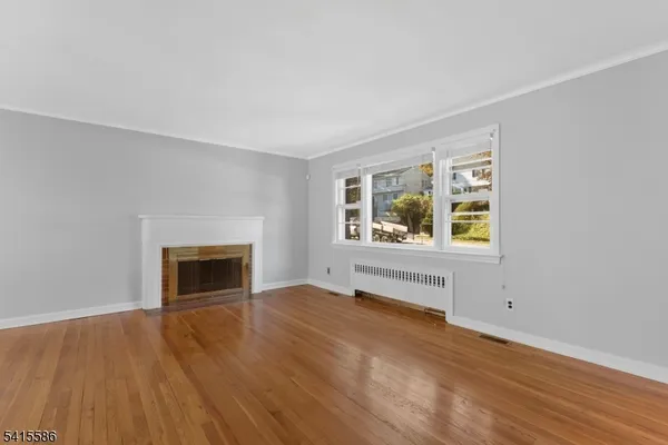 an empty room with windows and fireplace