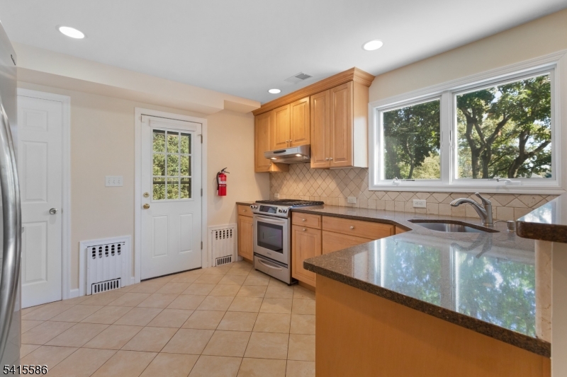 97 McCosh Road Montclair, NJ 07043 - Photo 8 of 25 a kitchen with stainless steel appliances granite countertop a sink and a stove