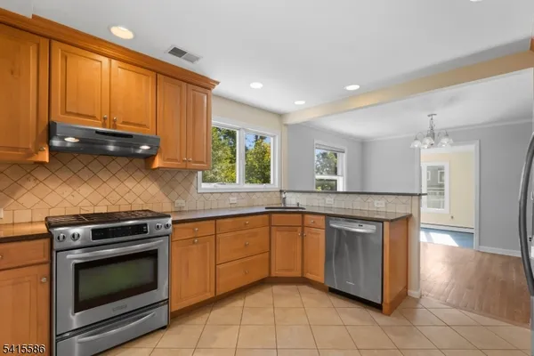 a kitchen with stainless steel appliances granite countertop a stove a sink and a microwave