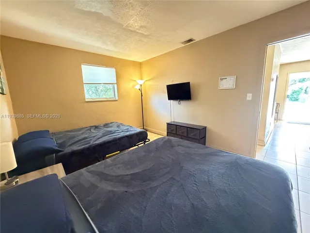 a bedroom with a bed and a flat screen tv