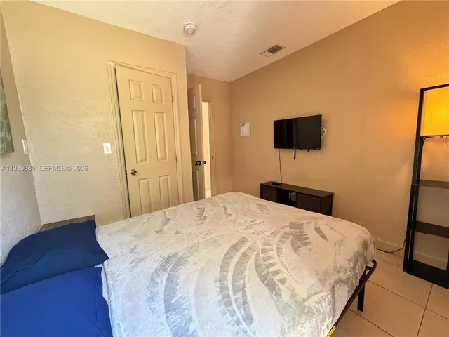 a bedroom with a bed and a flat screen tv
