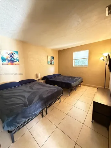 a bedroom with a bed a rug and painting on the wall