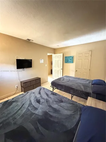 a bedroom with a bed and flat screen tv