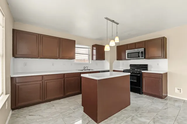 a kitchen with cabinets and steel appliances