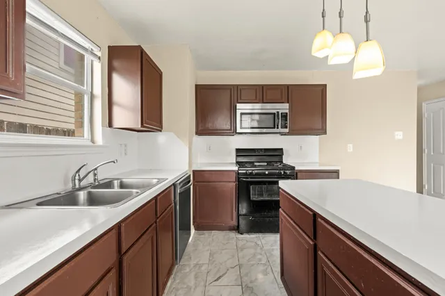a kitchen with stainless steel appliances granite countertop a sink and a stove