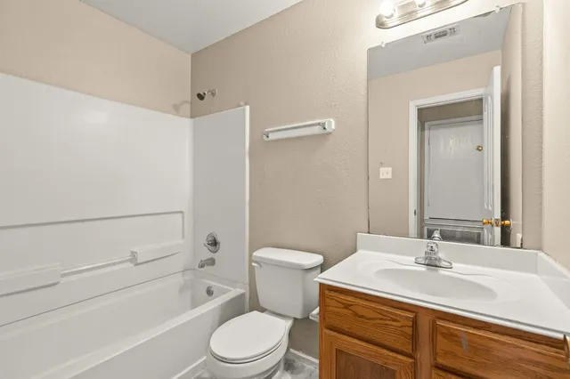 a bathroom with a sink toilet vanity and shower